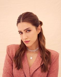 a woman with long hair wearing a pink shirt and silver choker on her neck