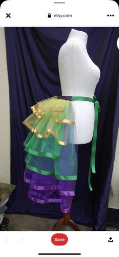 a mannequin is dressed up with colorful clothing on it's dummy stand