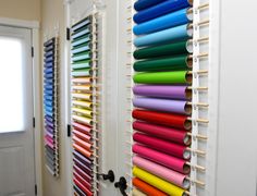 colorful rolls of colored paper are hanging on the wall next to a door with shutters