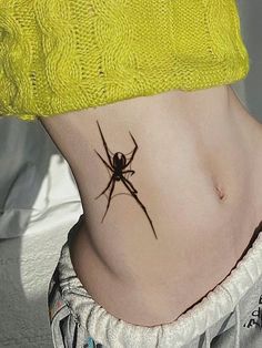 a woman with a spider tattoo on her stomach