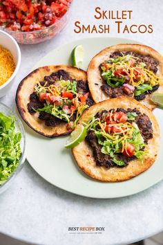 three tacos on a plate next to bowls of salad