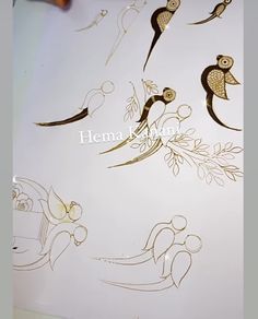 an image of some birds and flowers on a white sheet that is being drawn with gold ink