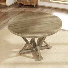 a round wooden table sitting on top of a rug