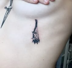 a woman with a tattoo on her stomach holding a knife in one hand and a dagger in the other