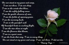 a white rose sitting on top of a green leaf covered table next to a poem