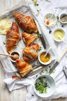 baked croissants on parchment paper with dipping sauces and condiments