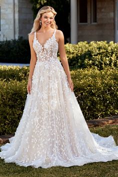 a woman in a wedding dress standing on the grass