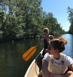 two people in a canoe paddling down a river with trees on either side and the caption reads,