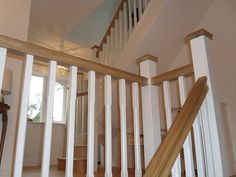 an open staircase in a house with white railings and wood handrails on either side