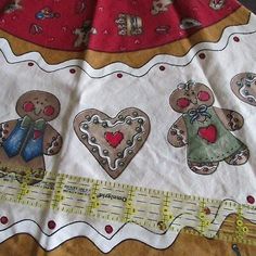 a piece of cloth with teddy bears on it and measuring tape in front of it