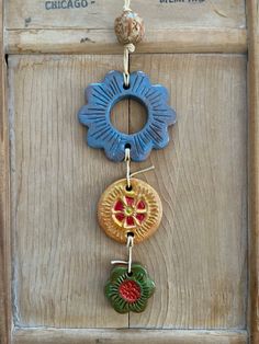 an old wooden door with three colorful ornaments hanging from it's side and the words chicago above them