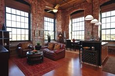 a living room filled with furniture and large windows