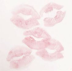 four pink lips are arranged in the shape of a circle on a white surface,