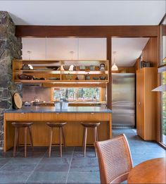 an open kitchen and dining area with wooden furniture