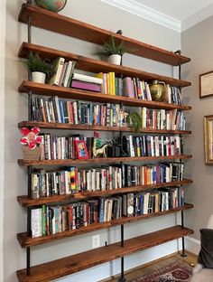 a bookshelf filled with lots of books next to a wall mounted planter