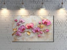 a white brick wall with pink flowers painted on it and three lights above the room