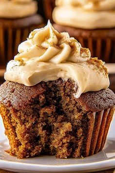 a cupcake with frosting and cinnamon sprinkles sits on a plate