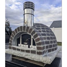 an outdoor brick pizza oven sitting on top of a grill