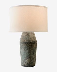 a table lamp with a white shade on it's base and a light bulb in the shape of a vase