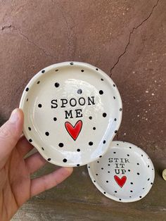 someone is holding two small plates that say spoon me and star up