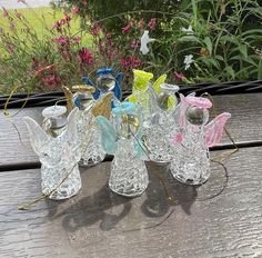 several glass angel figurines sitting on top of a wooden table