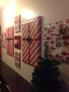 christmas presents wrapped in red and white paper are hung on the wall next to a tree