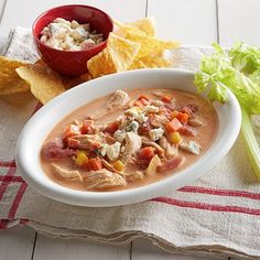 a bowl of chicken tortilla soup next to some chips