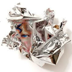 a piece of tin foil with a woman's face painted on the side and blue eyes