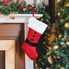 a red christmas stocking hanging from a fireplace mantel next to a decorated christmas tree