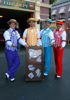 three men in colorful outfits are posing with a sign that says, disneyland's fire department