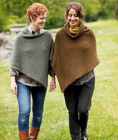 two women walking in the grass holding hands