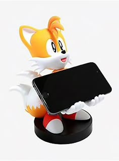 an orange and white cat holding a cell phone in it's paws while standing on a black base