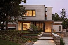 a modern house with steps leading up to the front door