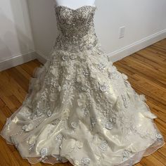 a wedding dress is displayed on a mannequin in a room with wood floors