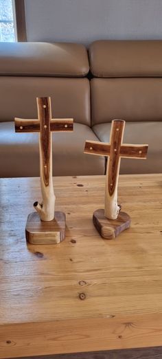 two wooden crosses sitting on top of a table