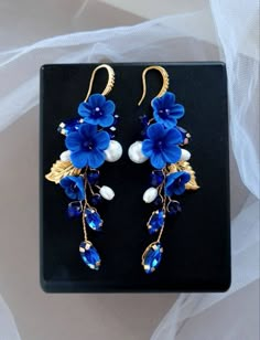 Dark blue earrings are light and ellegant. Earring length about 3 inches. The clasp on the earrings is made of hypoallergenic metal. Dark blue flower earrings consist of ceramic pearls, crystal rhinestones, crystal beads, polymer clay flowers, jewelry wire. * All orders from the Exclusive Wedding Shop you will receive in a FREE beautiful gift box. * Standard shipping: - USA: 12-15 business days - Europe: 3-5 weeks - Canada: 6-10 weeks - Australia: 6-10 weeks - Rest of World: 4-10 weeks * Express shipping UPS: 7-9 business days (around the world). If you have any questions about this product - please contact me. I will be happy to help you. Thank you for visiting my shop.  With best wishes, your Julia Bushmanova 💕 Cheap Handmade Blue Flower Earrings, Blue Handmade Flower-shaped Earrings, Elegant Blue Drop Clip-on Earrings, Blue Formal Flower-shaped Earrings, Blue Flower-shaped Formal Earrings, Handmade Blue Bridal Drop Earrings, Formal Blue Flower-shaped Earrings, Blue Handmade Flower Drop Earrings, Handmade Blue Drop Bridal Earrings