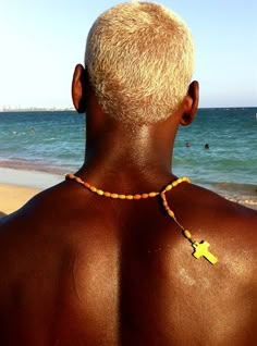 the back of a man wearing a necklace with a cross on it