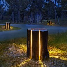 an outdoor area with some lights on the ground and trees in the background at night