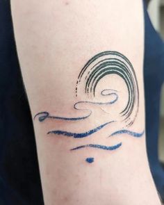 a person with a tattoo on their arm that has waves coming out of the water