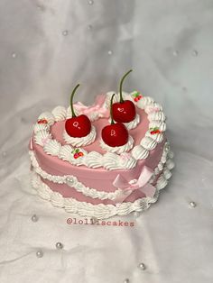 two cherries on top of a heart shaped cake