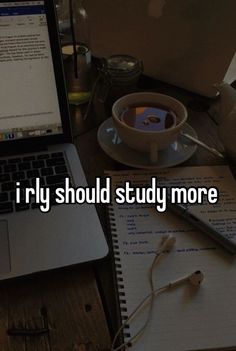 an open laptop computer sitting on top of a desk next to a cup of coffee