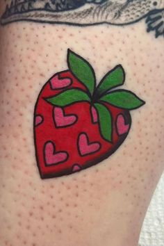 a strawberry tattoo with hearts on it