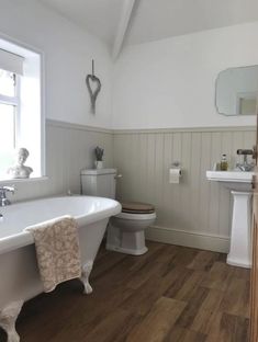 a white bath tub sitting next to a toilet in a bathroom