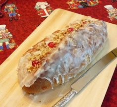 a wooden cutting board topped with a donut covered in frosting