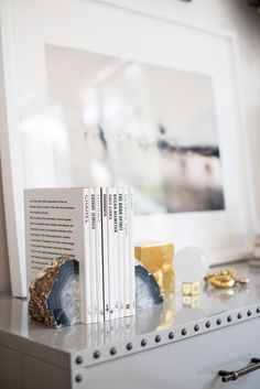 two books sitting on top of a white shelf