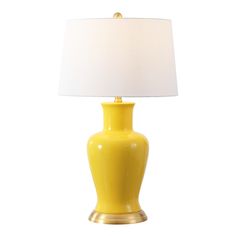 a yellow table lamp with a white shade