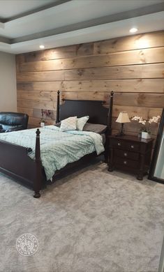 a bedroom with a bed, dressers and chair in front of a wood paneled wall