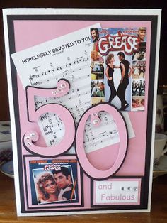 a pink and black 50th birthday card with some music memorabilia on the front, along with an envelope that says 50