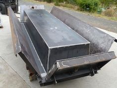 a large metal box sitting on the side of a road next to a truck and another vehicle