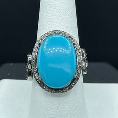 This Is A Beautiful Natural Turquoise And Diamond Ring Set In Sterling Silver. This Ring Features A Beautiful Turquoise That Measures 11.31 Carats In Size As Well As 0.63 Carats Of Diamonds. The Ring Weighs 7.1 Grams And The Deck Of The Ring Measures 17.80 X 16 Mm. This Turquoise Originated In Arizona And The Ring Is Size 8.5. Turquoise Promotes Self-Realisation And Assists Creative Problem Solving. It Is A Symbol Of Friendship, And Stimulates Romantic Love. Turquoise Is The Gemstone Associated With December. This Ring Is Handmade And One Of A Kind. Formal Turquoise Multi-stone Rings, Formal Turquoise Rings With Gemstone Accents, Formal Fine Jewelry Turquoise Ring With Accent Stones, Turquoise Ring With Diamond Accents, Turquoise Ring With Diamond Accents For Anniversary, Blue Turquoise Ring With Diamond Accents For Wedding, Oval Diamond Turquoise Ring For Formal Occasions, Turquoise Cabochon Ring For Anniversary, Luxury Turquoise Cabochon Ring